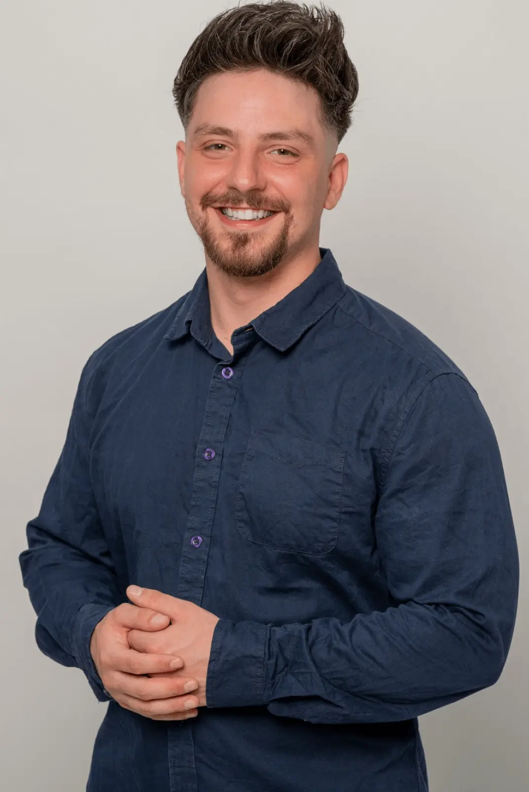 Dozent Jannes B. im blauen Hemd lächelt